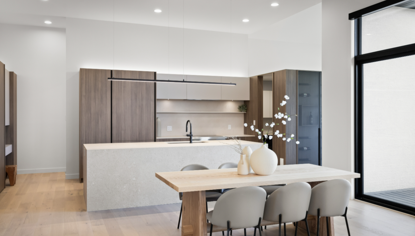 Minimalist kitchen and dining space with linear pendant lighting and quartz island