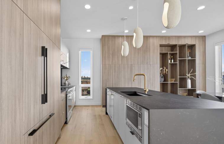 Modern kitchen with light wood cabinetry and sculptural pendant lighting